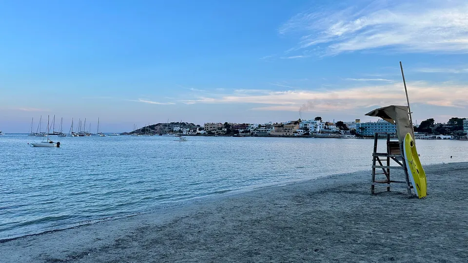 Talamanca beach at dusk with boats moored in the bay